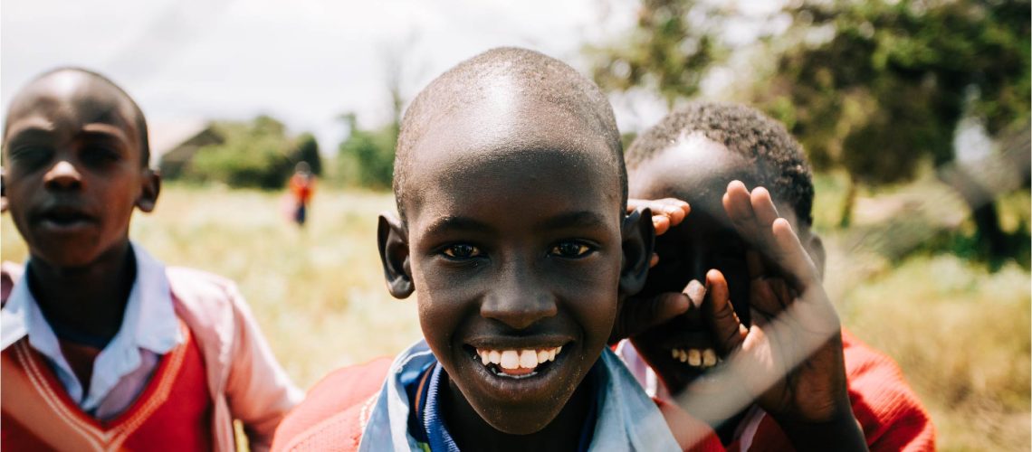 enfants africains regardent à travers d'une grille
